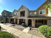 Inviting townhome featuring stone accents, a covered porch, and a well-maintained walkway to the entrance at 11207 Osage Cir # B, Northglenn, CO 80234