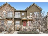 Two-story townhome with stone accents and a red door at 18847 E Yale Cir # D, Aurora, CO 80013