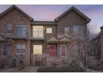 Two-story townhome with stone accents and a red door at 18847 E Yale Cir # D, Aurora, CO 80013