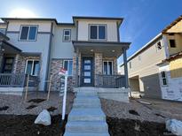 New construction two-story home featuring stone accents, covered entry, and a professionally landscaped front yard at 6609 N Netherland St, Aurora, CO 80019