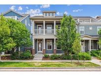 Charming two-story home boasts a cozy front porch, complemented by verdant landscaping and beautiful curb appeal at 11466 E 27Th Ave, Denver, CO 80238