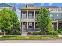 Charming two-story home boasts a cozy front porch, complemented by verdant landscaping and beautiful curb appeal at 11466 E 27Th Ave, Denver, CO 80238