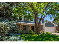 Charming two-story home with a manicured lawn and mature tree, offering a welcoming curb appeal at 5914 S Kearney St, Centennial, CO 80111