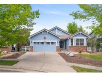 Charming blue home with a two-car garage, brick accents, and well-manicured front yard at 1118 S Duquesne Cir, Aurora, CO 80018