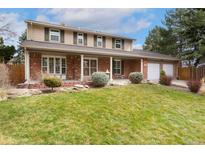 Charming two-story home with brick facade, covered front porch, and well-manicured lawn at 8510 Independence Way, Arvada, CO 80005