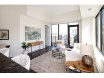 Bright living room boasts a large window, balcony access and contemporary decor, creating an inviting and stylish space at 1650 Fillmore St # 504, Denver, CO 80206