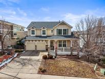 Charming two-story home with a welcoming front porch and a well-maintained yard on a sunny day at 743 Briar Haven Dr, Castle Pines, CO 80108