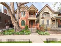 Charming two-story home with detailed architectural features and a black metal fence surrounding the manicured front yard at 3147 Vallejo St, Denver, CO 80211