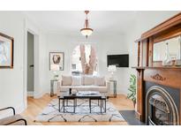 Bright living room features a fireplace, a large arched window, and modern furnishings at 3147 Vallejo St, Denver, CO 80211