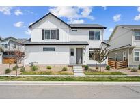 Charming two-story home features a white exterior, landscaped yard, and inviting front porch for curb appeal at 10224 Worchester St, Commerce City, CO 80022