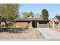 Charming brick home with attached garage, well-kept lawn, and inviting curb appeal at 3025 Forest St, Denver, CO 80207