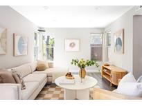 Bright living room featuring a comfortable couch, modern decor, and natural light from large windows at 3025 Forest St, Denver, CO 80207