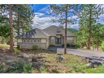 Charming home with stone accents, mature trees, and a welcoming entrance at 31042 Wildwoods, Evergreen, CO 80439