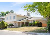 Charming two-story home featuring brick and siding, complemented by a well-maintained front yard and mature trees at 6463 S Vance St, Littleton, CO 80123
