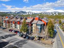 Scenic exterior of a multi-story building with a mountain view, parking and road at 107 N Harris St # 102, Breckenridge, CO 80424