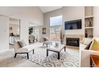 Bright living room with fireplace, vaulted ceilings, and natural light at 87 Macon Ct, Aurora, CO 80010