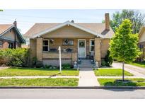 Charming brick home with a well-manicured lawn and inviting front porch, creating great curb appeal at 2026 S Lincoln St, Denver, CO 80210