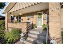 Inviting front porch with brick accents, decorative plants and room for seating at 2026 S Lincoln St, Denver, CO 80210