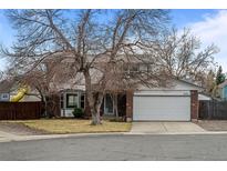 Charming two-story home with brick facade, mature trees, and a two-car garage in a residential neighborhood at 9560 W 104Th Ave, Broomfield, CO 80021
