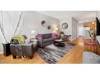 Bright living room features hardwood floors, modern decor, and comfortable seating arrangement at 4357 W 118Th Pl, Westminster, CO 80031
