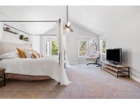 A stunning main bedroom with a canopy bed, views, and a hanging chair at 10000 E Yale Ave # 41, Denver, CO 80231