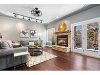 Cozy living room features a stone fireplace, hardwood floors, and access to the patio with natural light at 10000 E Yale Ave # 41, Denver, CO 80231