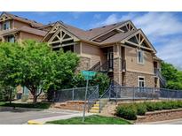 Attractive condo building featuring stone accents, brown siding, and well-maintained landscaping with a blue sky backdrop at 8726 S Kline St # A204, Littleton, CO 80127