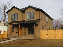Charming two-story home with a brick facade, covered porch and a well-maintained lawn at 1970 S Logan St, Denver, CO 80210