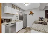 Compact kitchen features stainless steel appliances, light countertops, and white cabinets at 1611 Garfield Ave # 2, Louisville, CO 80027