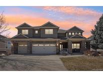 Charming two-story home with a three-car garage and well-maintained front yard under a beautiful pink and orange sky at 8131 S Coolidge Way, Aurora, CO 80016