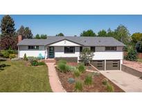 Charming ranch-style home with a landscaped front yard, a blue front door, and a two-car garage at 2125 Rangeview Ln, Longmont, CO 80501