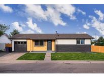 Charming single-story home featuring a combination of wood and brick exterior, complemented by a well-manicured lawn at 5304 Granby St, Denver, CO 80239