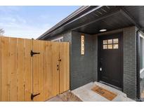 Stylish front entrance features black brick, a wooden gate, and a modern front door at 3377 N Krameria St, Denver, CO 80207