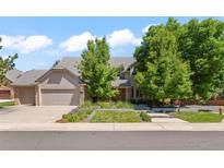 Beautiful two-story home with a well-manicured lawn, mature trees, and a three-car garage at 10293 E Sheri Ln, Englewood, CO 80111