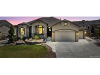 Charming stucco home featuring a well-manicured lawn, stone accents, and an attached two-car garage at 3255 Waterfront Dr, Monument, CO 80132
