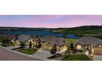 Scenic view of homes near a lake, showcasing landscaping and neighborhood charm under a colorful sky at 3255 Waterfront Dr, Monument, CO 80132