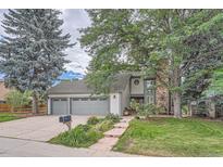 Charming two-story home featuring a three-car garage and a beautifully landscaped front yard with mature trees at 8216 S Krameria Way, Centennial, CO 80112