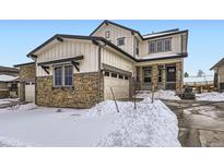 Beautiful two-story home featuring stone accents, a front porch, and an attached two-car garage at 17402 W 93Rd Pl, Arvada, CO 80007