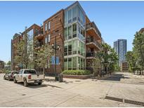 Brick building exterior view with glass windows, balconies, and a glimpse of the cityscape at 1401 Delgany St # 409, Denver, CO 80202