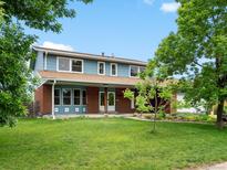 Charming two-story home with a well-manicured lawn and mature trees at 10978 Roseanna Dr, Northglenn, CO 80234