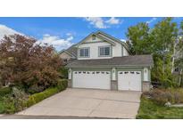 Charming two-story home featuring a three-car garage, lush landscaping, and a welcoming facade at 248 Summit Trl, Broomfield, CO 80020
