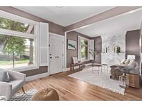 Bright living room featuring hardwood floors, large windows, and a decorative fireplace at 368 S Humboldt St, Denver, CO 80209