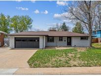Charming single-story home with a well-maintained lawn, attached garage, and classic brick detailing at 6913 Teller Ct, Arvada, CO 80003