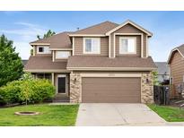 Two-story home featuring a well-manicured lawn, attached two-car garage and neutral-tone exterior at 23222 E Orchard Pl, Aurora, CO 80015