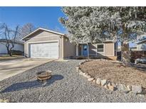 Charming single-story home featuring a well-maintained front yard with a large tree and a two-car garage at 4783 S Taft St, Morrison, CO 80465