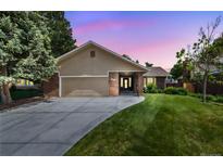 Charming exterior of a home with a lush green lawn and a driveway leading to an attached garage at sunset at 37 E 14Th Pl, Broomfield, CO 80020