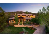 Expansive, two-story luxury home featuring a lush green yard, a stone path, and a mountain in the background at 722 Evening Star Dr, Castle Rock, CO 80108