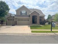 Charming two-story home featuring a stone-accented entrance, spacious three-car garage, and well-maintained front lawn at 14096 Roaring Fork Cir, Broomfield, CO 80023
