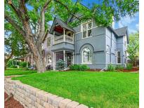 Charming two-story home with a well-manicured lawn and mature trees, providing curb appeal at 444 S Pearl St, Denver, CO 80209