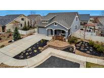 Charming home featuring a well-manicured lawn, complemented by landscaped garden beds and a spacious driveway at 5519 Genoa St, Denver, CO 80249